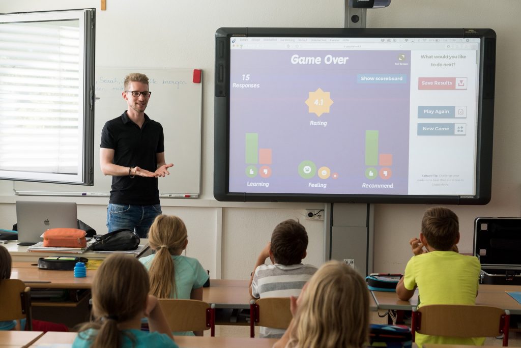 Teaching health skills 

A teacher standing in front of a school class, with a Kahoot on the board.