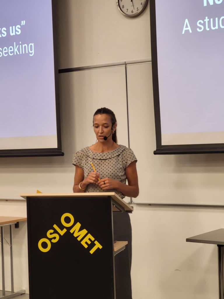 Birgit Kvikne står ved talerstolen og forteller om avhandlingen sin.