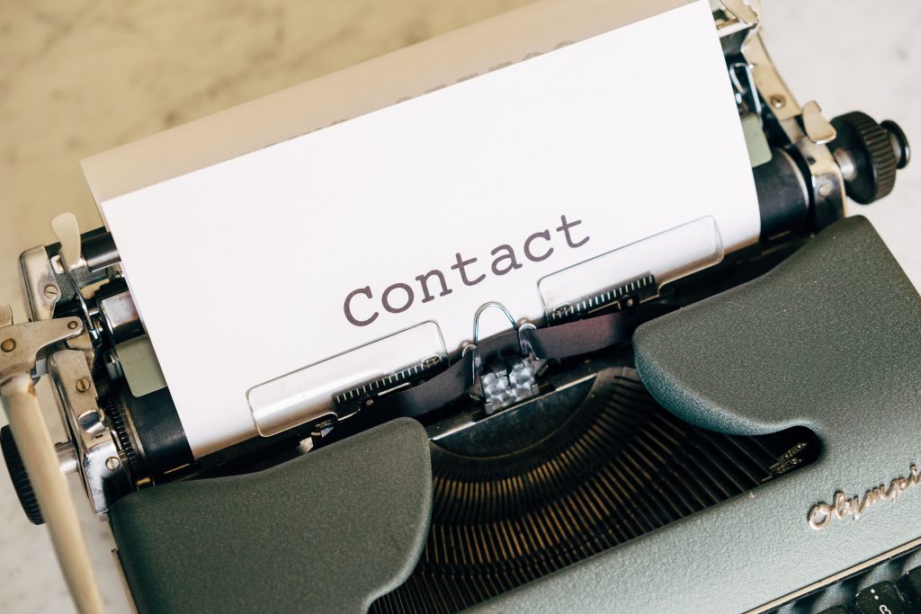skrivemaskin med et ark hvor det står "kontakt"