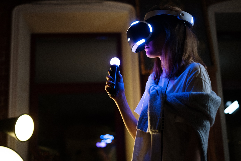 A girl using a VR headset and controller to game.