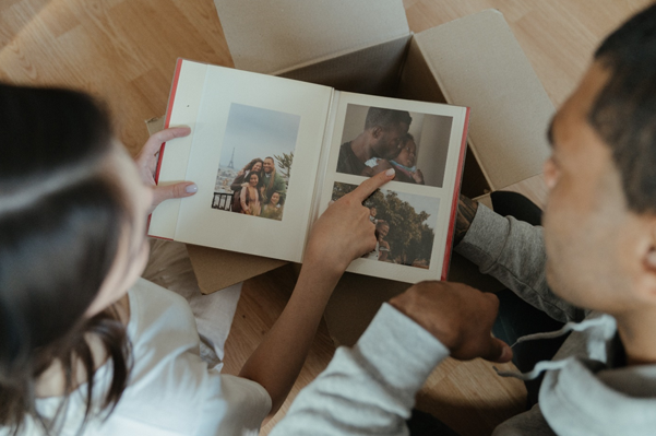 Two people looking at old pictures in a photo book