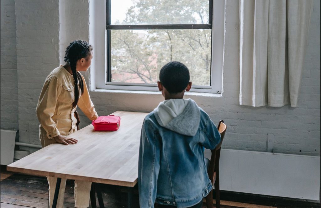 Picture of two kids with one lunch box.