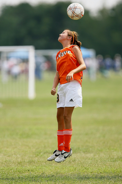 Girl in football wear playing football