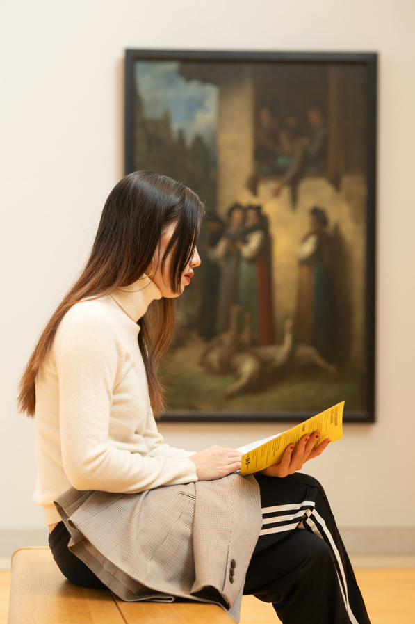 Young woman sitting in a museum reading