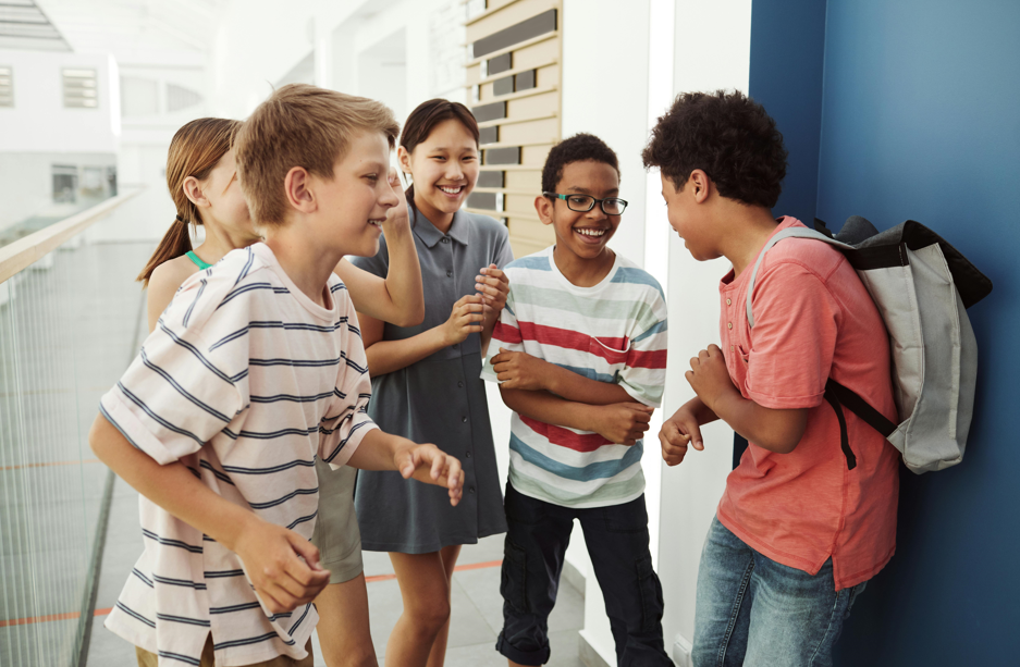 A group of children standing together and joking.