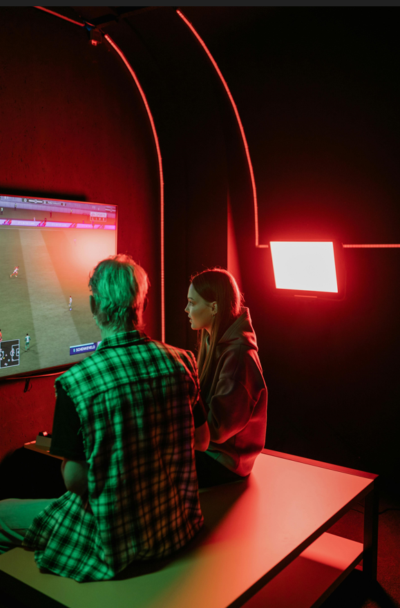 Two teens sitting in front of a video game chatting and gaming together