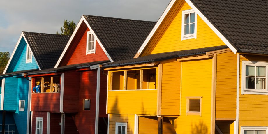 Gult, rødt og blått trehus i rekke.