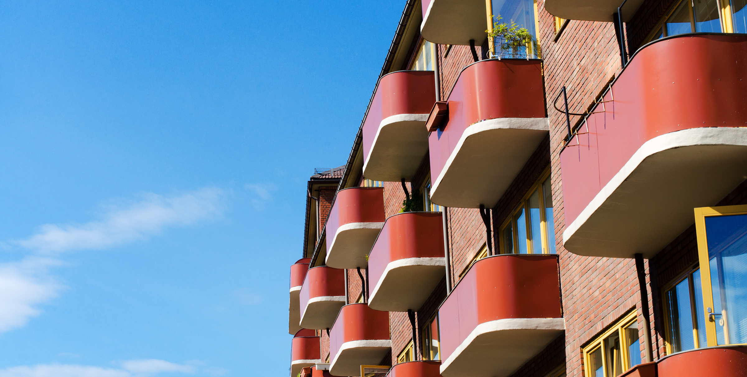 Røde avrundede balkonger på blokk i Oslo.