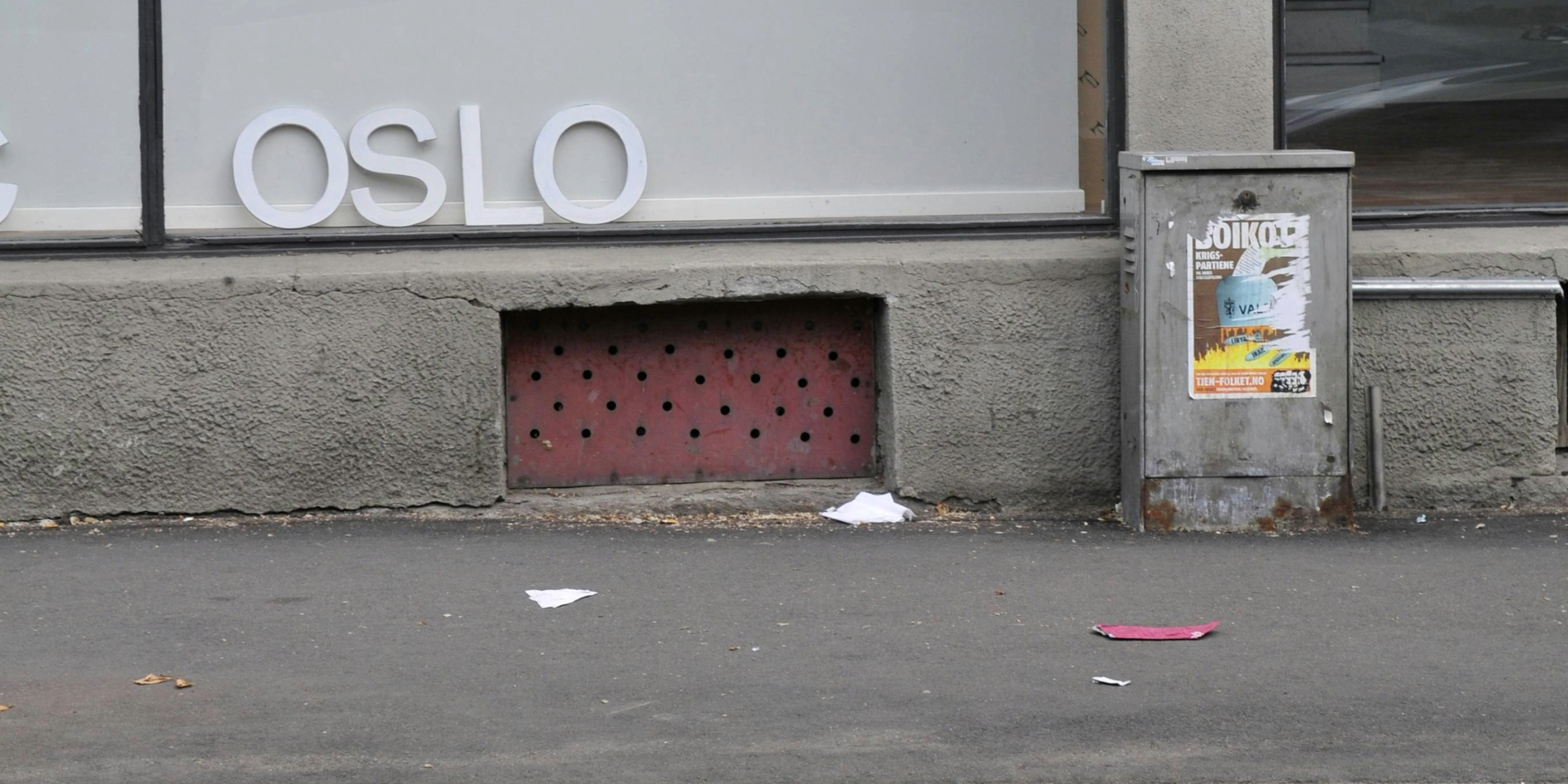 Bilde av en gate i Oslo med søppel på bakken. Bokstaver i et vindu der det står Oslo.