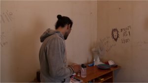 man looking at items on a dresser