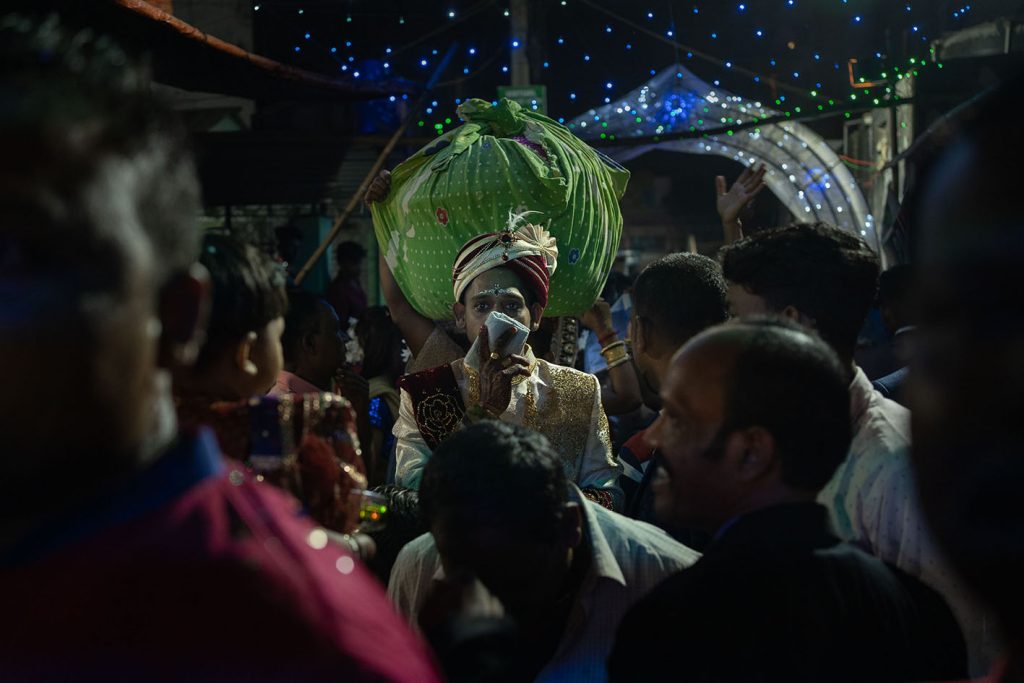 man in crowded street holding a cloth over his mouth.