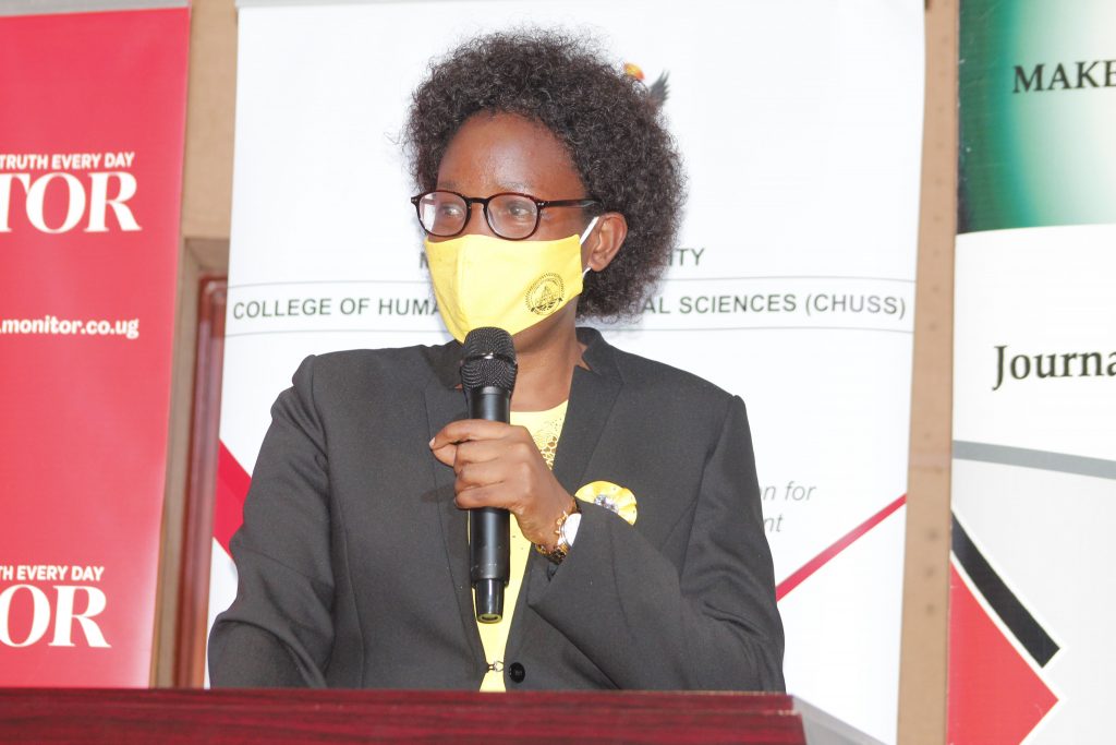 speaking on a podium wearing a mask