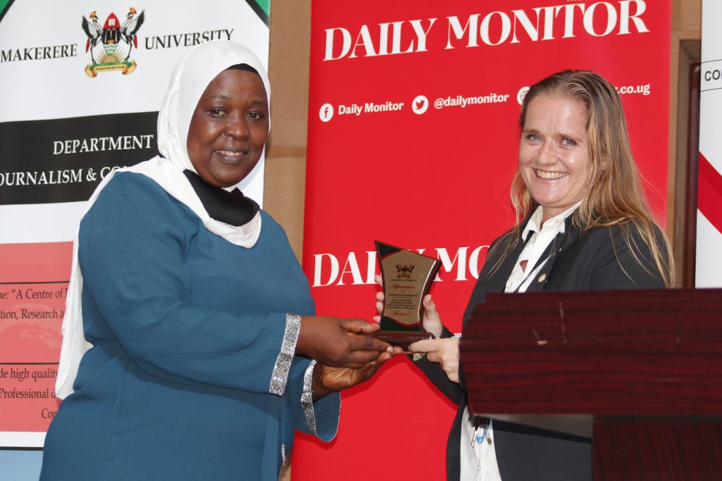 Dr. Sauda Namyalo handing over a plaque to Kjersti Lindøe they are both smiling