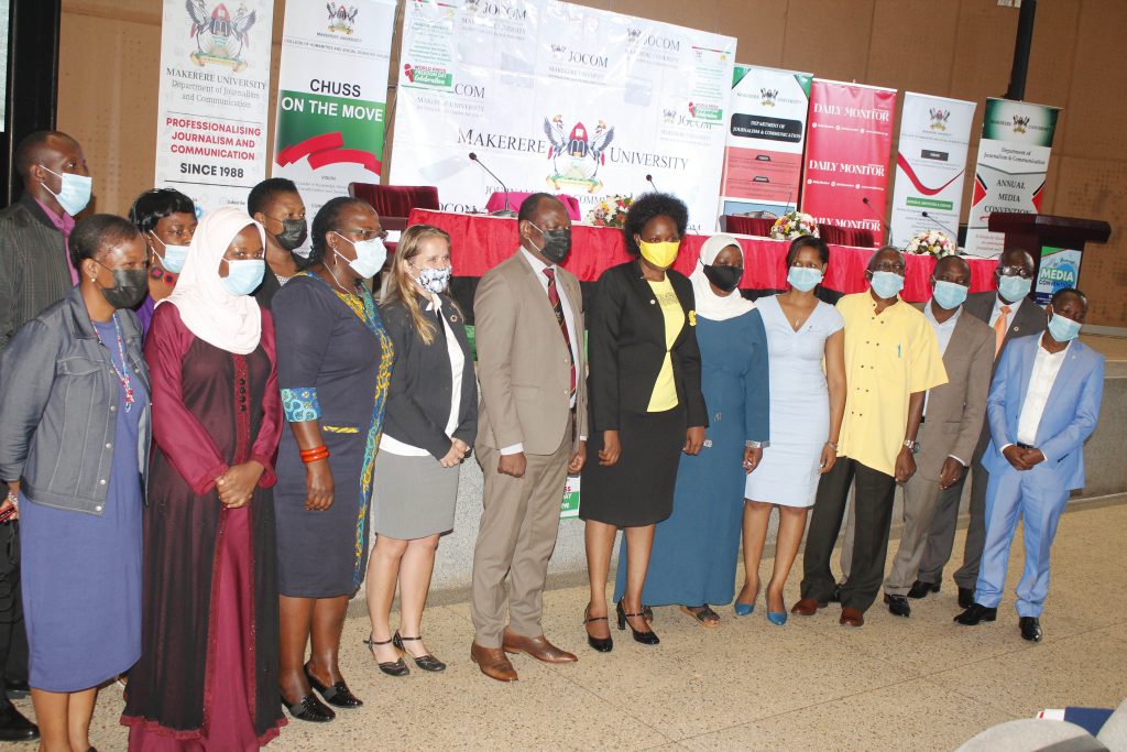 a groupe of Makerere University staff standing on a line wearing masks