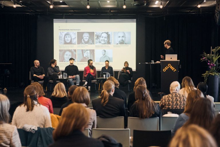 Paneldeltagere som diskuterer på scenen.