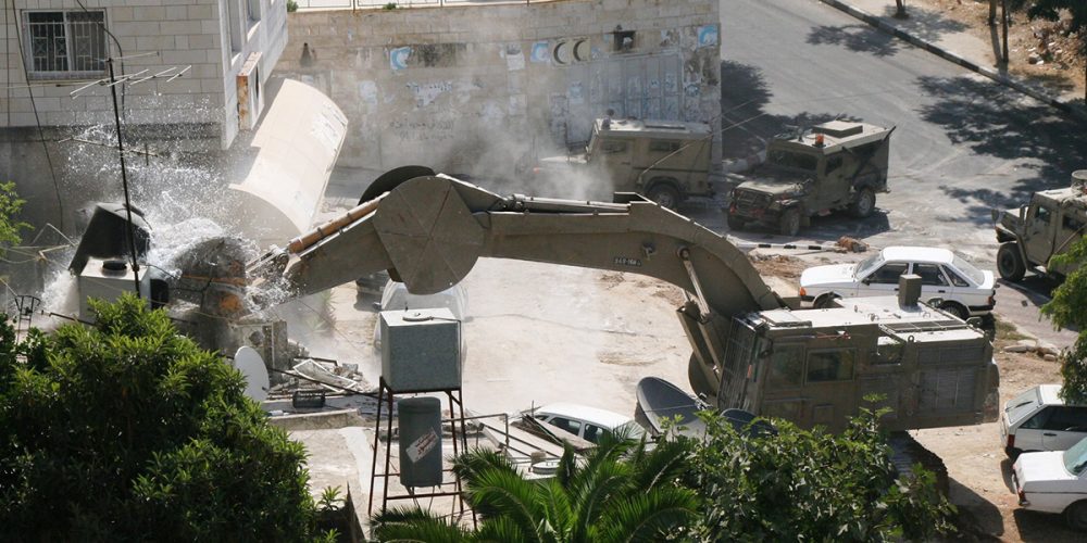En gravemaskin fra Catapillar ødelegger et hus på Vestbredden, Palestina.