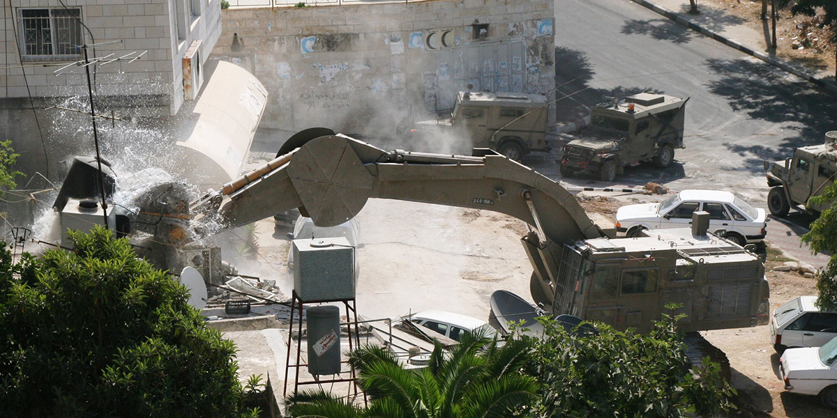En gravemaskin fra Catapillar ødelegger et hus på Vestbredden, Palestina.