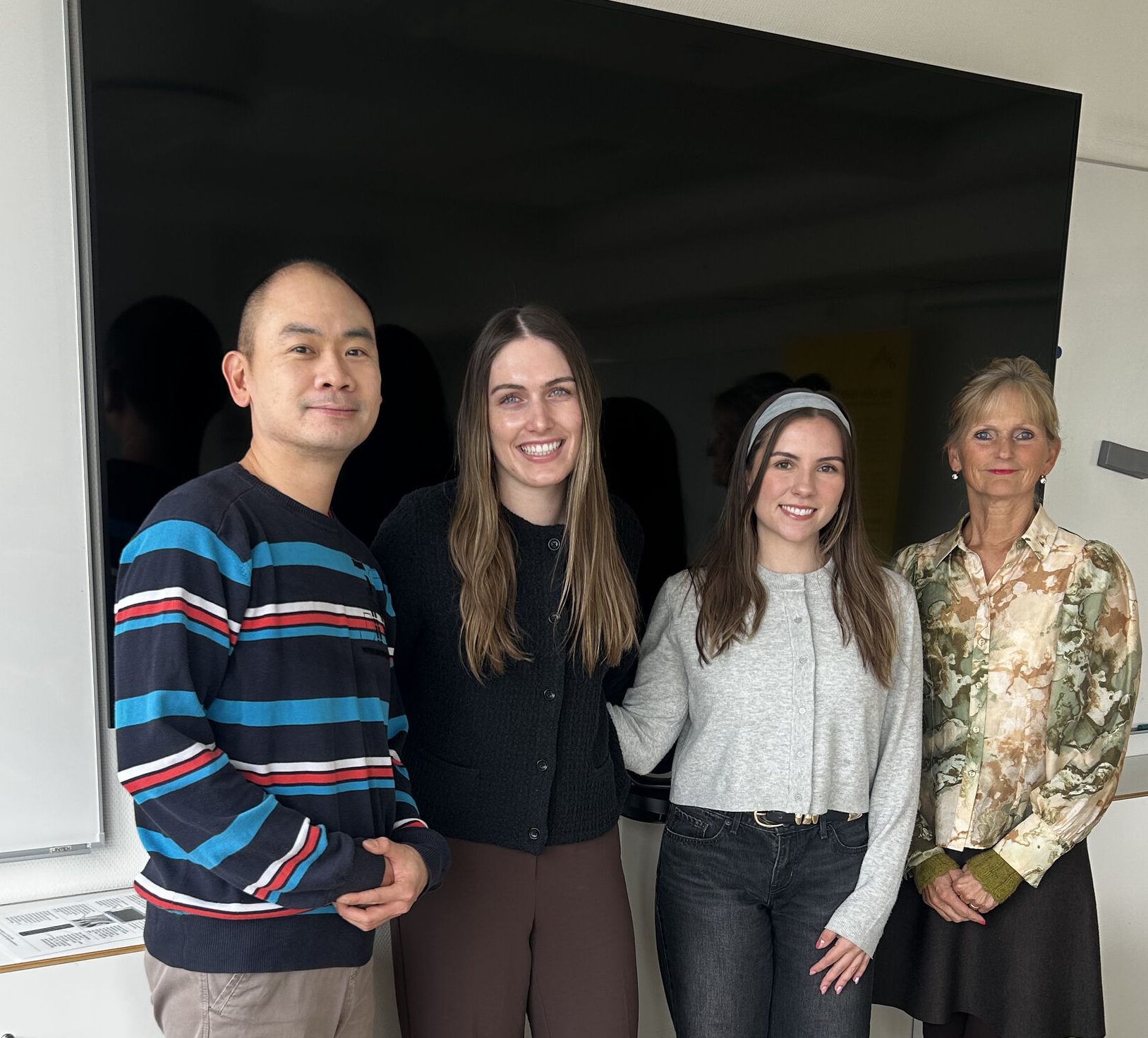 Pic of Bong, Abby, Lauren and Anne standing in front of a smart TV