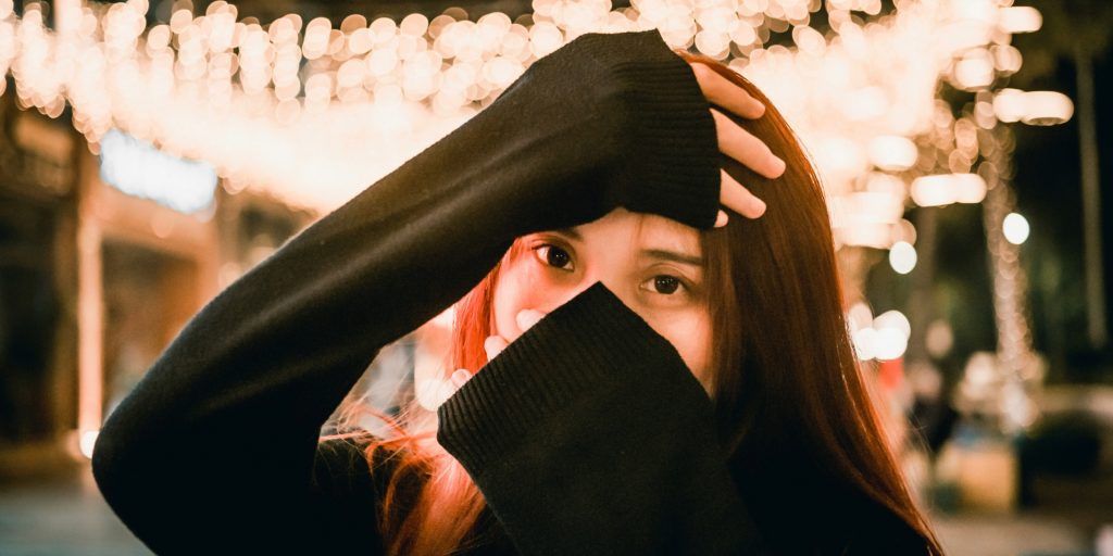 Bilde av jente som holder hendene på panne og over munn