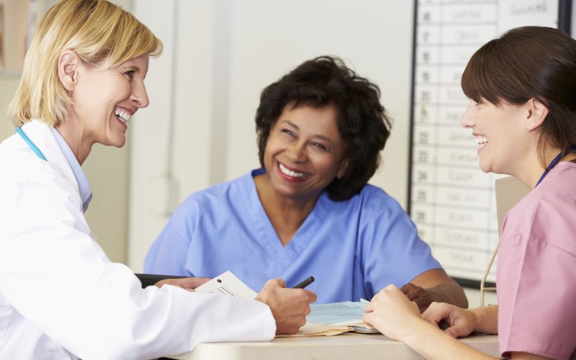 A female doctor talking to two female nurses.