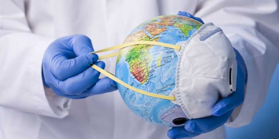 Health worker holding a globe with face mask